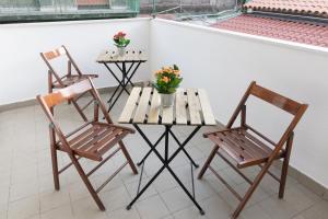 2 Stühle und ein Tisch mit Blumen auf dem Balkon in der Unterkunft R-Home Exclusive Rooms in Catania + 29 Fotos