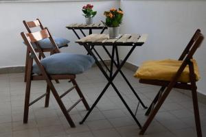 2 Stühle und ein Tisch mit Blumen drauf in der Unterkunft R-Home Exclusive Rooms in Catania
