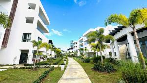 a street in front of a building with palm trees at Moderno Apartamento Frente Al Mar in La Iglesia