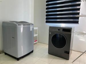 a dryer and a washing machine in a room at Deandra Homestay- WiFi-Aircond-Dryer in Sungai Petani
