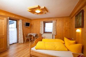 um quarto com uma cama com almofadas amarelas em Apart Luca em Längenfeld
