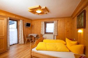 a bedroom with a bed with yellow pillows at Apart Luca in Längenfeld