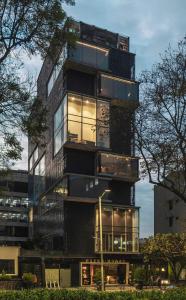 波哥大The Click Clack Hotel Bogotá的一座高大的建筑,有许多玻璃窗
