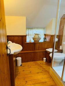 a bathroom with a sink and a toilet in it at The Snug at Cherry Cottage by MaisonPro in Matson +20 photos
