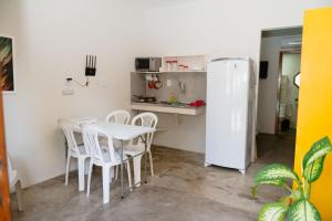 a kitchen with a table and a white refrigerator at Casa Natureza in Camaçari