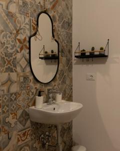 ein Badezimmer mit Waschbecken und Spiegel in der Unterkunft R-Home Exclusive Rooms in Catania