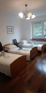 a room with three beds and a chandelier at Ночлеги - Pokoi in Tarnowo Podgórne