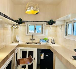 a kitchen with a sink and a chair in it at Rooftop Studio with Private Sun Terrace in Ouakam