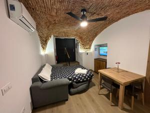 ein Wohnzimmer mit einem Bett und einem Tisch in der Unterkunft Entre Bóvedas in Cáceres