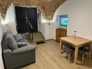 ein Wohnzimmer mit Sofa und Tisch in der Unterkunft Entre Bóvedas in Cáceres