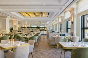 ein Restaurant mit Tischen und Stühlen und einer Bar in der Unterkunft JW Marriott Hotel Berlin in Berlin