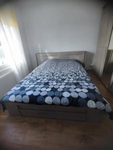 Bett mit blauer und weißer Decke in einem Zimmer in der Unterkunft Chambre double- SDB et WC Privé in Morlaix