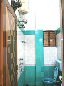Un baño con inodoro azul y ducha. en Rater Tara Diner Rabi Resort, en Santiniketan