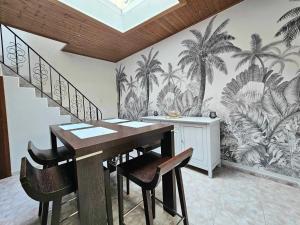 a dining room with a table and some palm trees mural at appartement 1ch mons centre in Mons