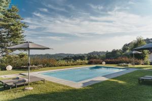San Fermo della Battaglia特努娜隆科雷吉奥农家乐的一个带两把遮阳伞和两张长椅的游泳池