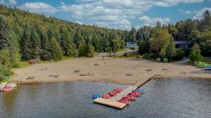an aerial view of a beach with boats in the water at Le Alesund, 5BR avec SPA, PLAGE et embarcations in Sainte-Lucie-de-Doncaster +44 photos