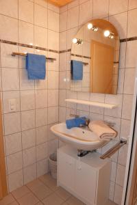 ein Bad mit einem Waschbecken und einem Spiegel in der Unterkunft Haus Carnot in Samnaun