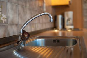 a sink in a kitchen with a faucet at Scheibenhof in Bad Gastein