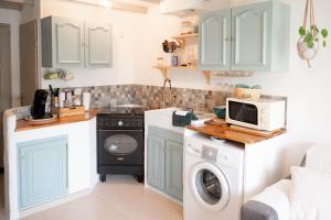 a kitchen with a washing machine and a microwave at Maisonnette au calme in Saint-Vallier-de-Thiey