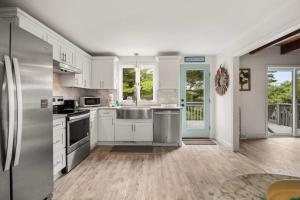 a kitchen with white cabinets and stainless steel appliances at Pond Front Home w Game Room Dog Friendly in Chatham +27 photos