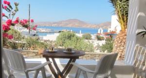 einen Tisch und Stühle auf einer Terrasse mit Meerblick in der Unterkunft Despina's Mare in Naoussa