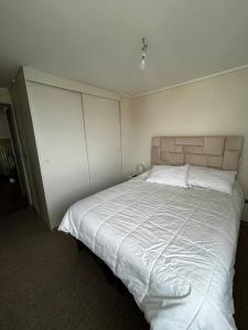 a bedroom with a large bed with white sheets at Departamento amoblado in Los Ángeles