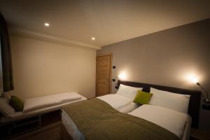 a bedroom with two beds with green and white pillows at Chalet Alfonz in Bormio
