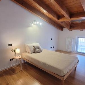 a bedroom with a large bed in a room with wooden ceilings at Carlotta Mountain Lake Iseo Hospitality in Bossico +24 photos
