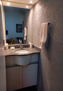 a bathroom with a sink and a mirror at Flat Duplex - Flat & Residence Premium in Campo Grande