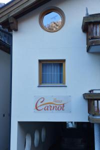 ein weißes Gebäude mit einem runden Fenster und dem Namen Tampons in der Unterkunft Haus Carnot in Samnaun