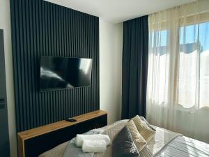 a bedroom with a bed with a television on a wall at Forum Apartment in Krakow