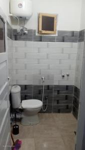 un baño con inodoro y lavabo en Next to the bus stop, en Siwa