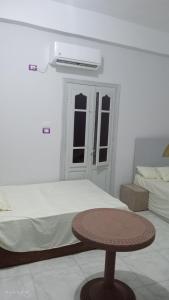 Habitación con cama y mesa junto a la cama en Next to the bus stop, en Siwa