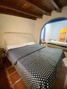 a bedroom with a black and white bed in a room at Casa Rústica con jardínes en excelente ubicación in Atamo