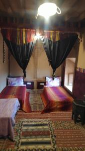 Postel nebo postele na pokoji v ubytování Kasbah Maktob Tamnougalt