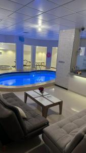 a large swimming pool with a table in front of it at شاليه قطر الندى - الطائف in Taif