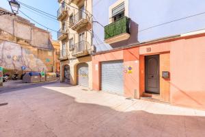 an alley with a building with a garage at Oli by Unik Vacation in Tarragona