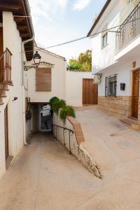 an alleyway between two white buildings with plants on it at Casa Callejón de las Morenicas in Cazorla