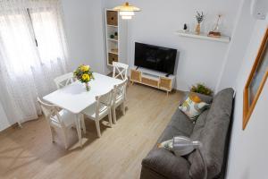 a living room with a table and a couch at Casa Callejón de las Morenicas in Cazorla +14 photos