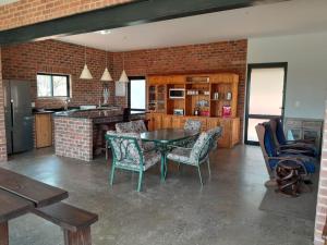 cocina con mesa, sillas y pared de ladrillo en Elements Golfers Lodge 123, en Moheme