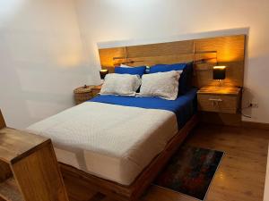 a bedroom with a large bed with blue sheets and pillows at Lomas de las Mercedes in Caracas