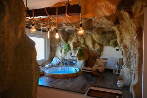 a large bathroom with a tub in a stone wall at B&B La Casa nella Roccia in Villanova del Battista