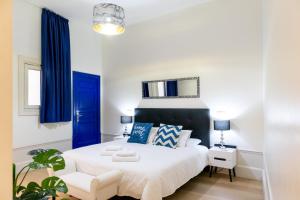 sypialnia z białym łóżkiem i niebieskimi zasłonami w obiekcie Ever House - CHUECA-GRAN VIA w Madrycie