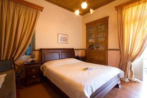 a bedroom with a bed and a dresser and curtains at Archontiko in Mystras
