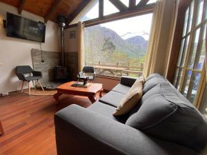 a living room with a couch and a large window at Cabaña Rústica con Vista y Entorno Natural in Río Blanco