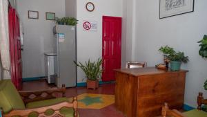 a room with a red door and a table and chairs at Hotel Petenchel in Flores