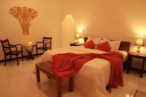 a bedroom with a bed with a red blanket on it at The Cattleya Guest House Sigiriya in Sigiriya