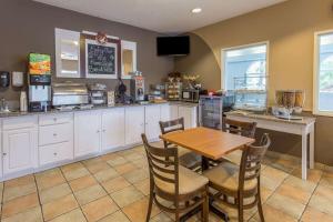 a kitchen with a table and chairs and a counter at Rock Island Inn & Suites Streator , IL in Delbert Egan Housing Project