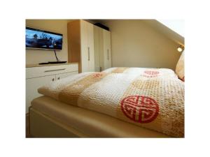 a bedroom with a bed with a television on it at Holiday apartment Balkenstek in Norddeich