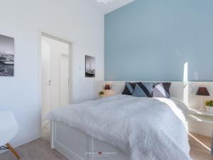 una camera da letto bianca con un letto e uno specchio di An-der-Ostsee-17 Comfortable holiday residence a Kappeln